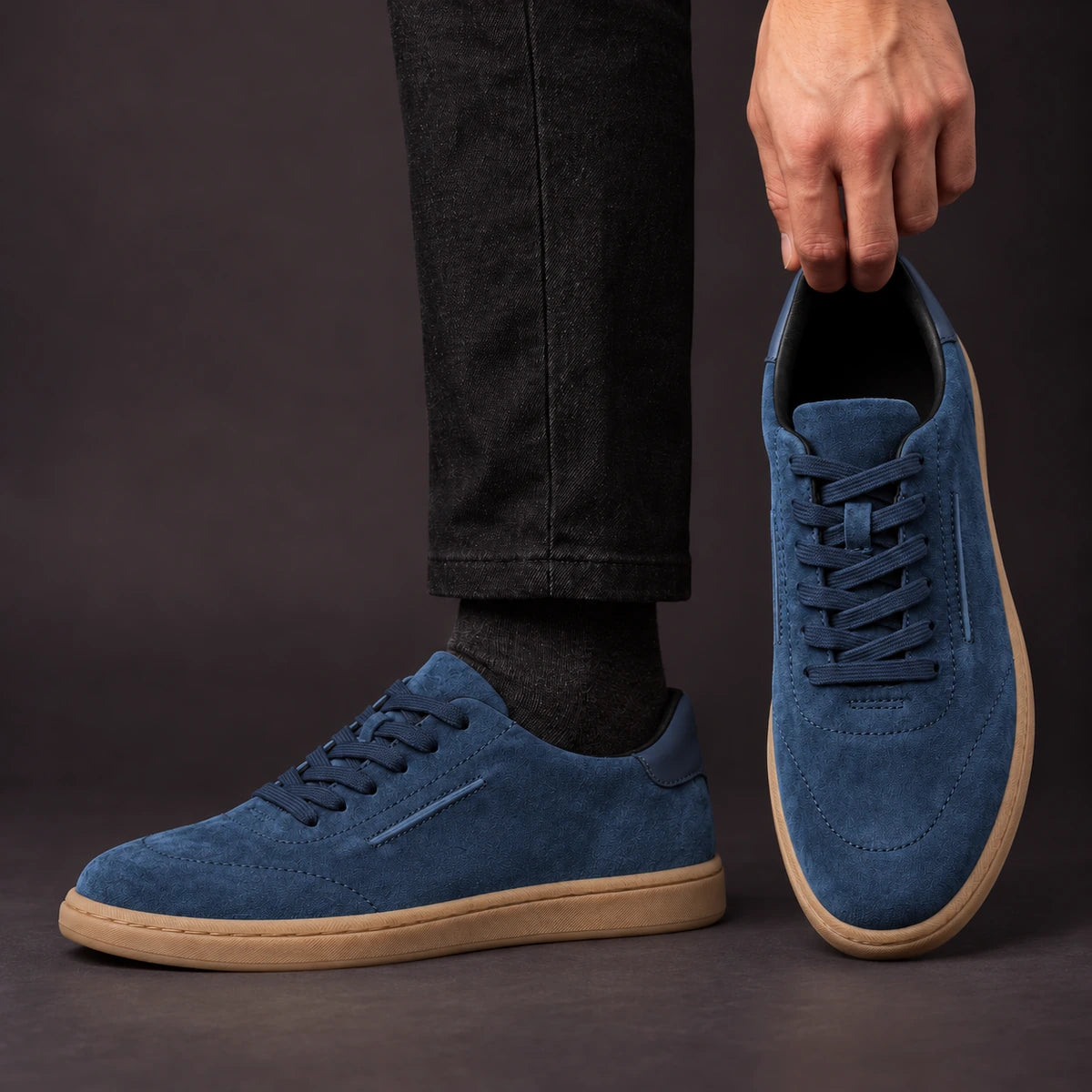 Leather Sneakers | Willem Blue model holding shoe by heel opening beside matching worn shoe