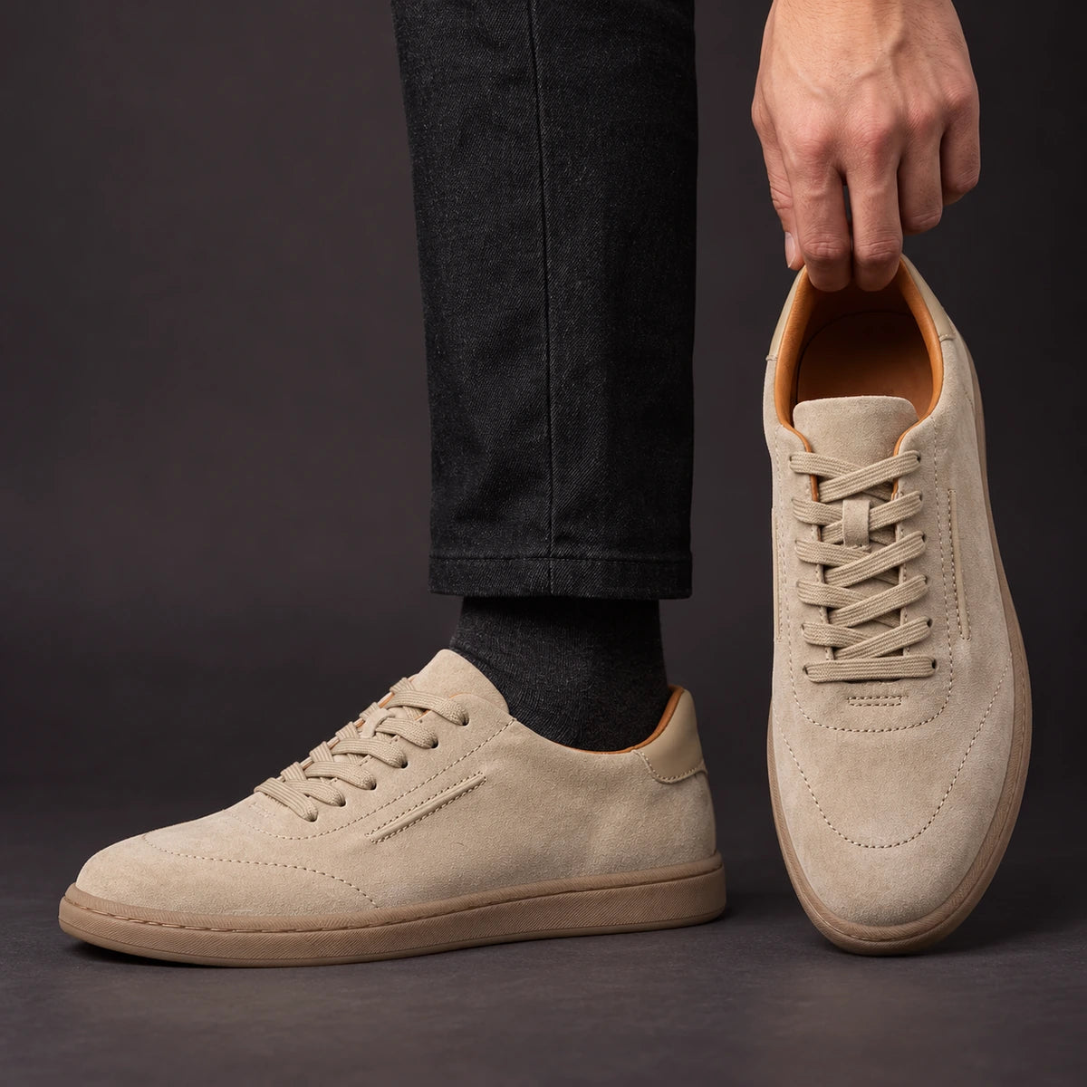 Leather Sneakers | Willem Sand model holding shoe by heel opening beside matching worn shoe