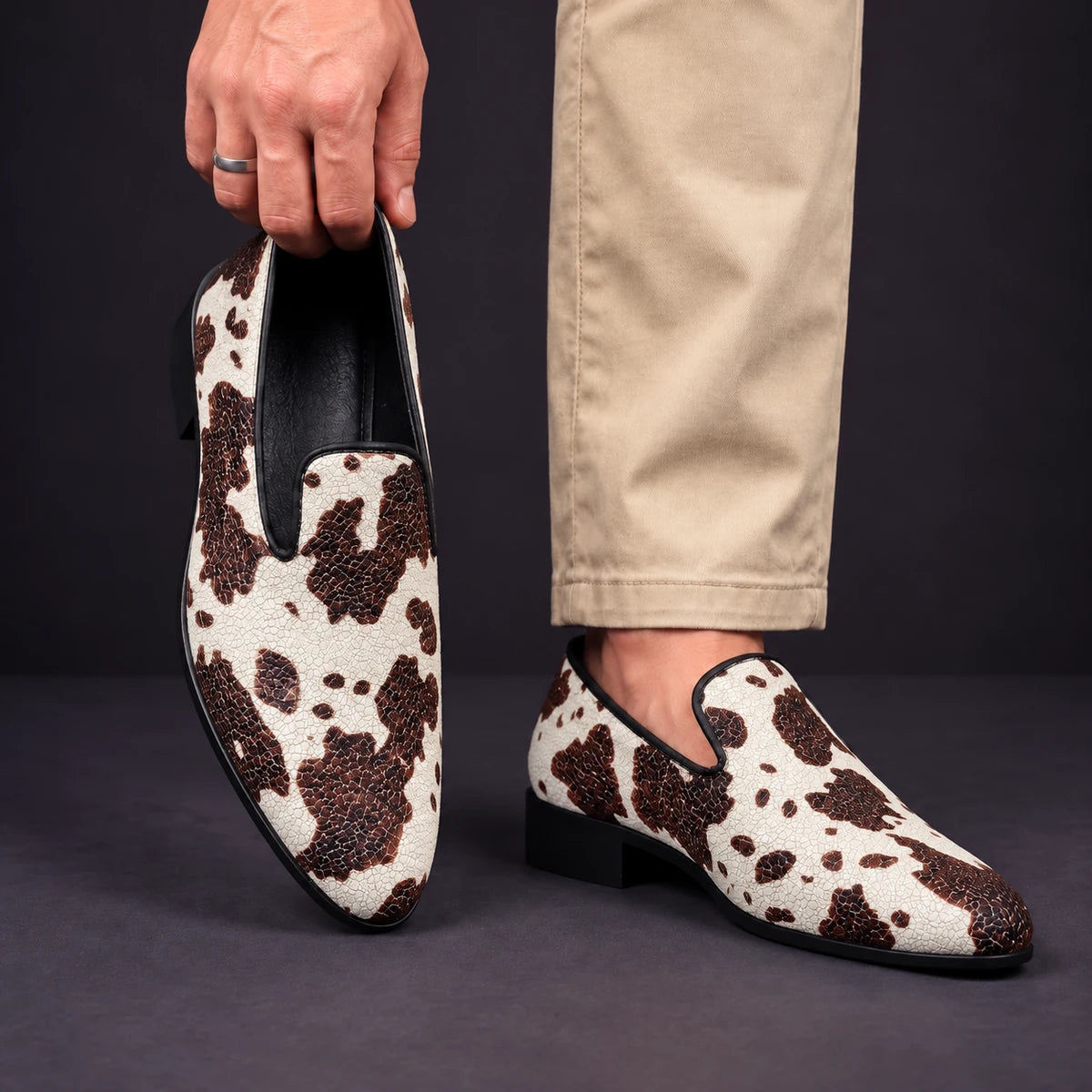 Printed Loafers | Valentin Brown model holding shoe by heel opening beside matching worn shoe