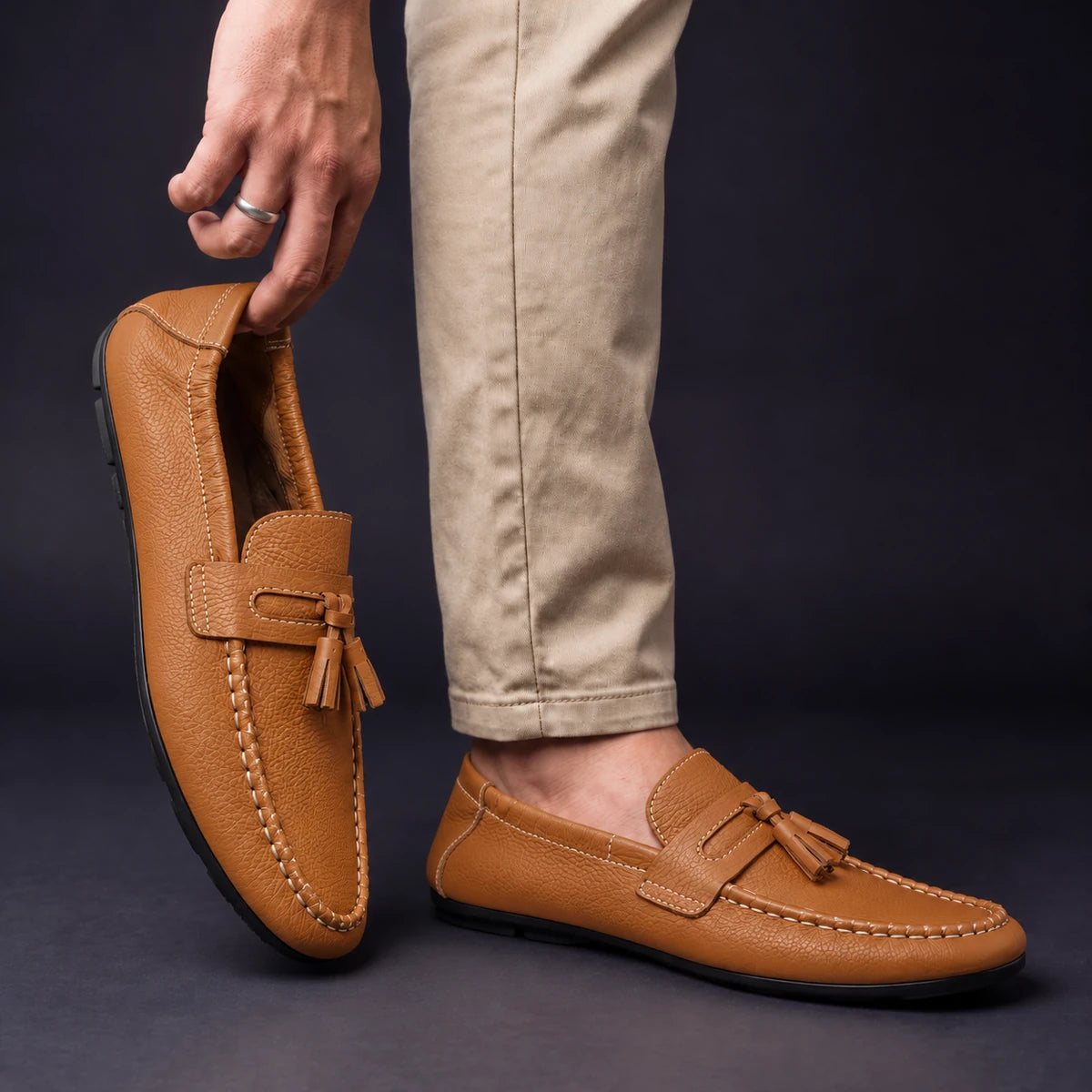 Cowhide Leather Loafers | Viggo Brown model holding shoe by heel opening beside matching worn shoe