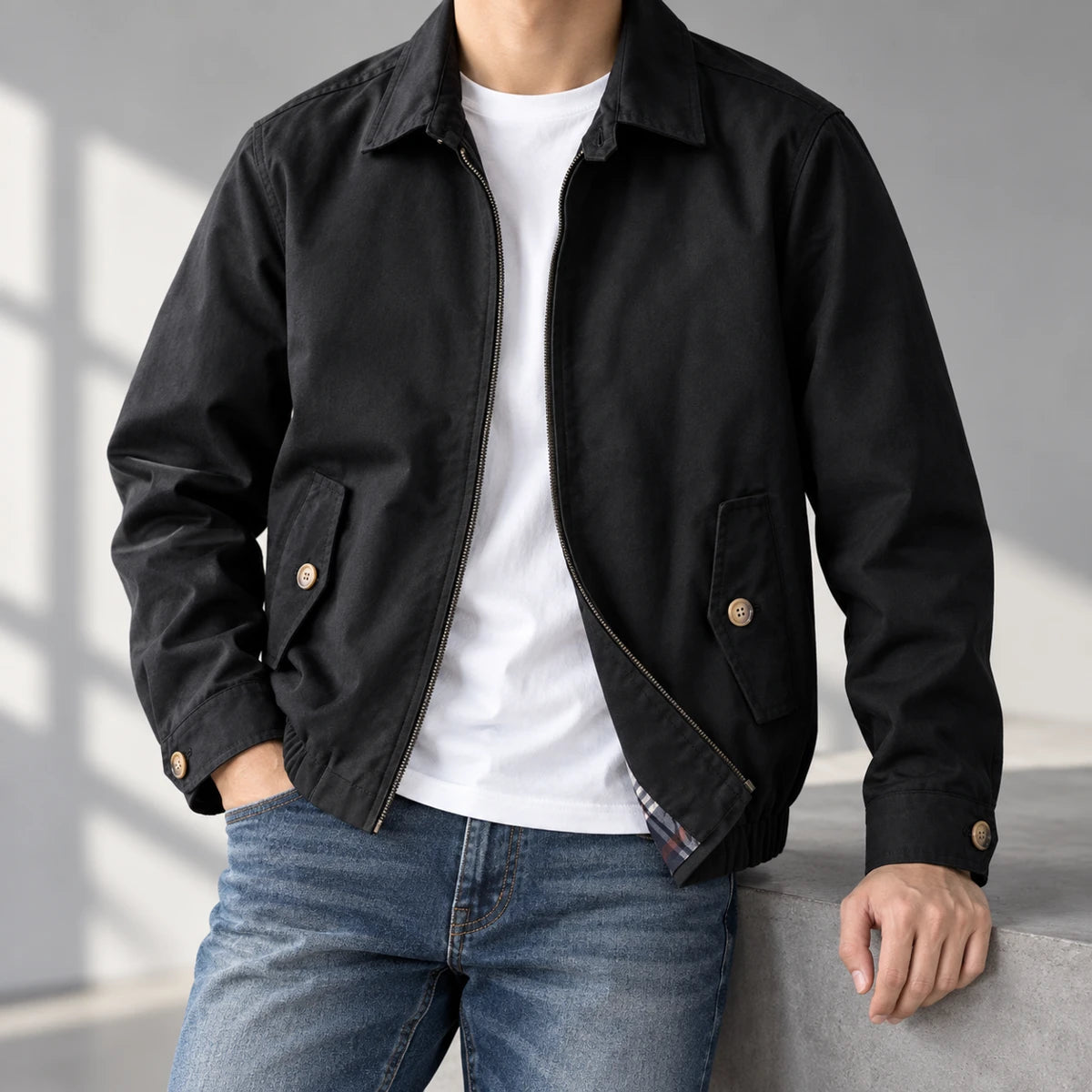 Cotton Harrington Jacket | Felix Black neck-down wearer casually leaning on gray studio ledge