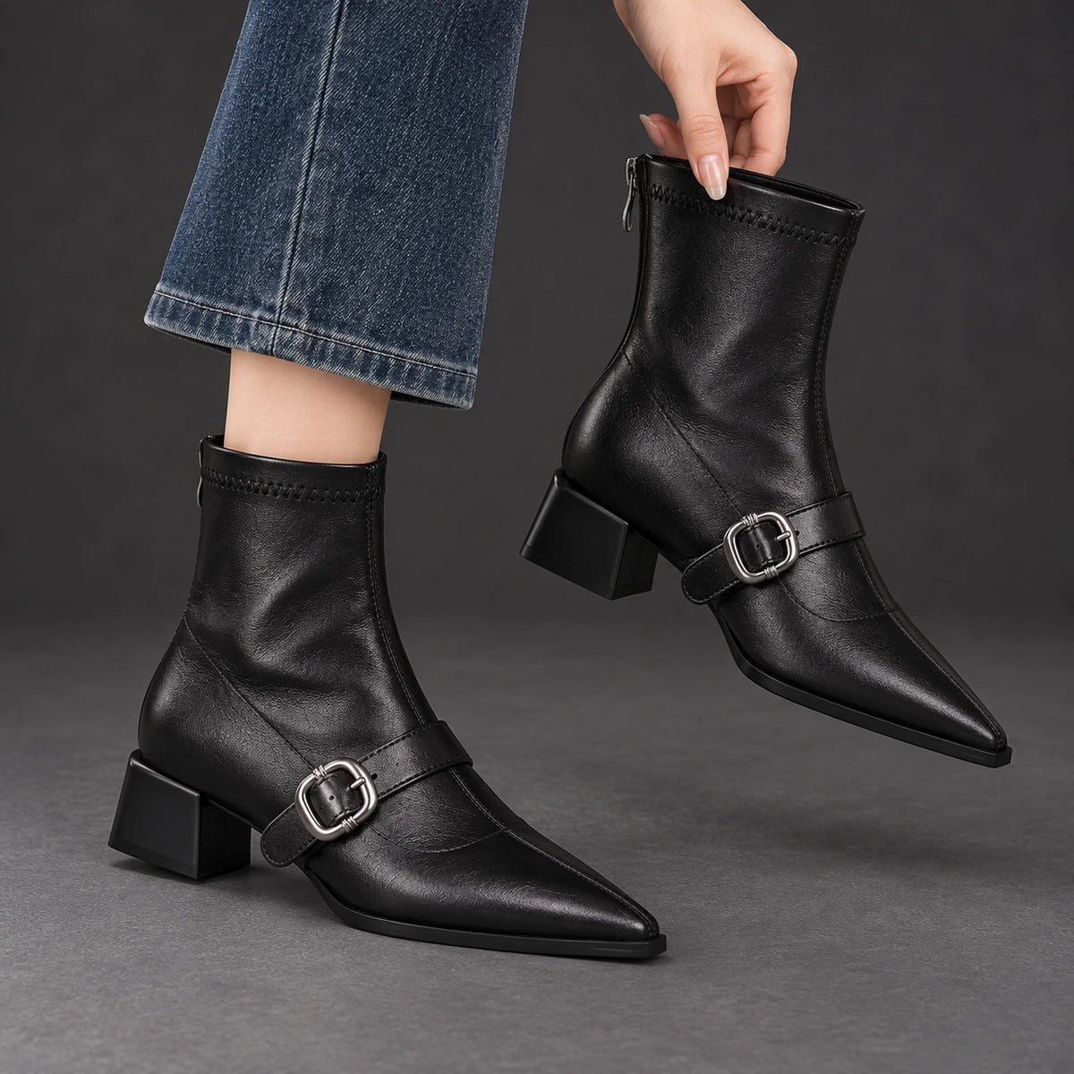 Pointed Toe Buckle Ankle Boots | Serena in Black, one boot held beside its worn matching boot